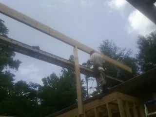 Carpenter setting a ridge beam over a new addition frame — Ice Dam Removal by Roofing Brothers in Morton Grove