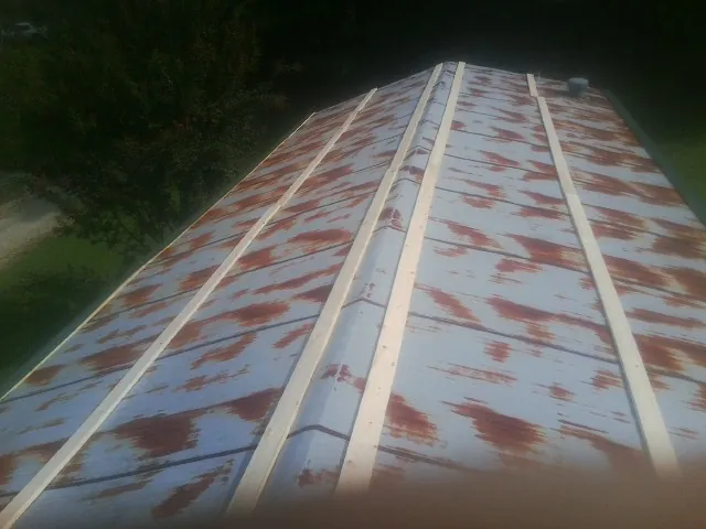 Rusted metal roof panels with new wood purlins before replacement — Storm Damage Roof Repair in Morton Grove by Roofing Brothers