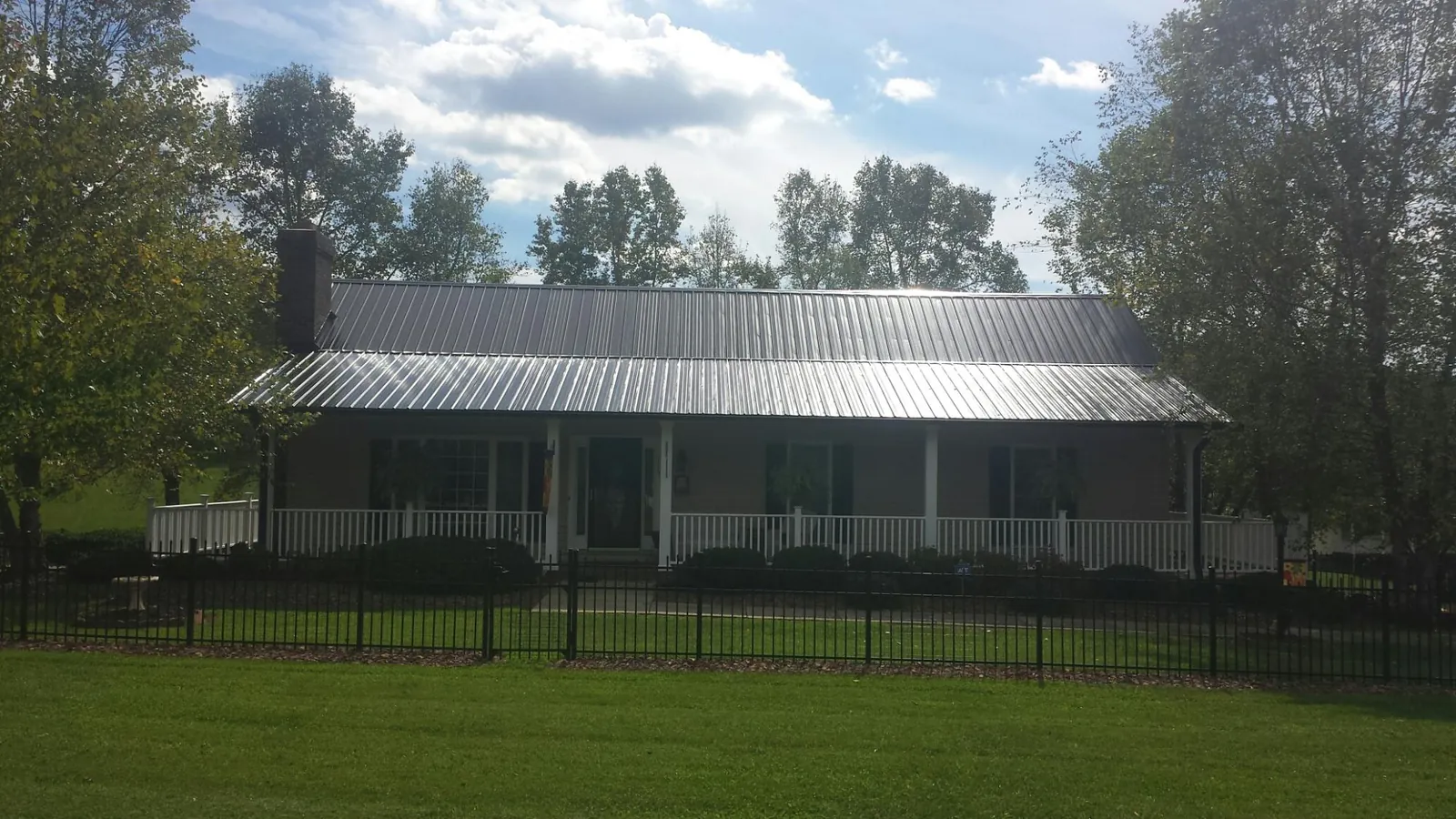 Gray metal roof on a brick ranch with a full width front porch — Gutter Guard Installation work by our crew in Morton Grove