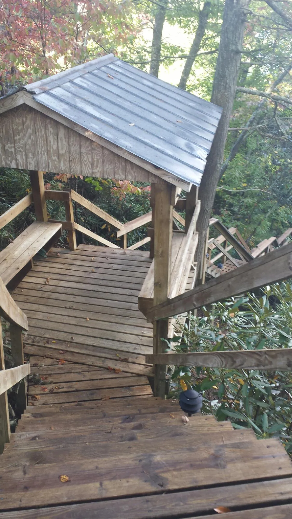 Metal roofed shelter over wooden steps on a wooded walkway — Skylight Repair & Installation work by our crew in Morton Grove