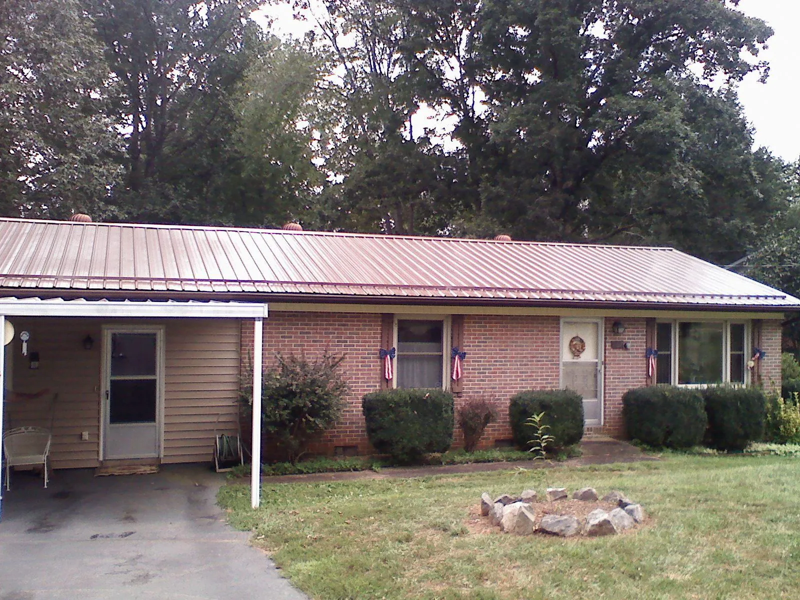 Bronze metal roof and carport on a brick ranch home — Roof Repair work by our crew in Morton Grove